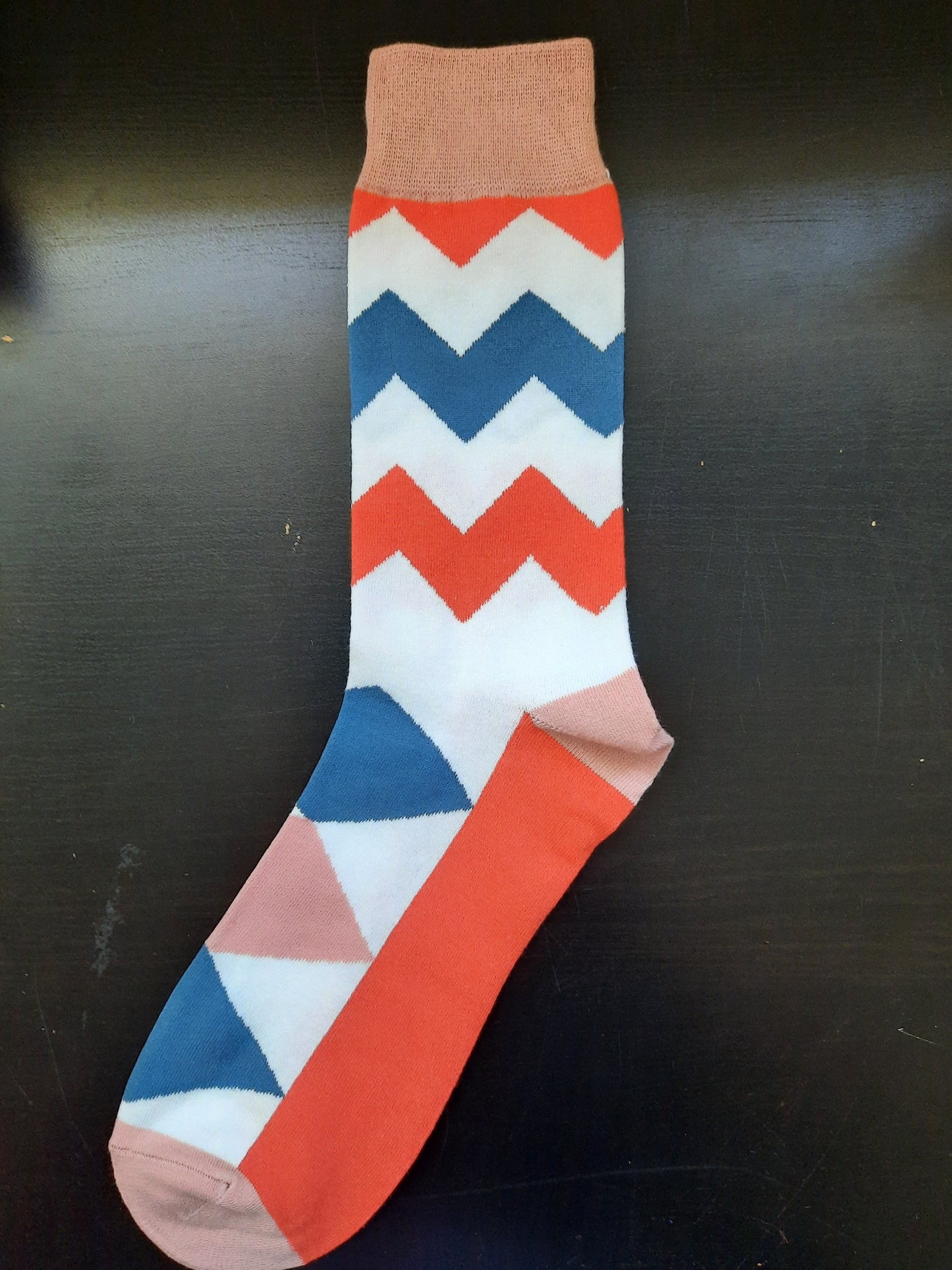 Burnt orange socks with white and blue zig zags and diamonds